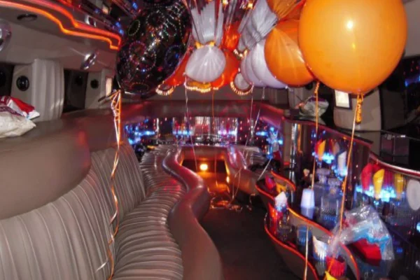 Luxurious interior of a Detroit Limo Service vehicle decorated with orange and white balloons for a party or special event.