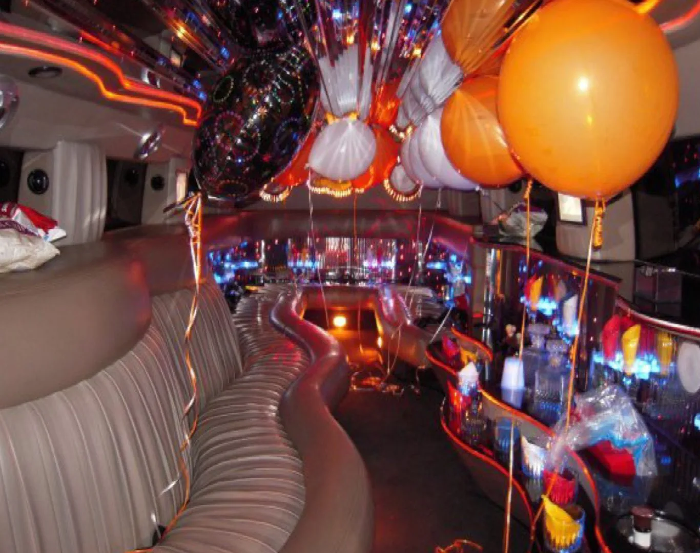 Luxurious interior of a Detroit Limo Service vehicle decorated with orange and white balloons for a party or special event.